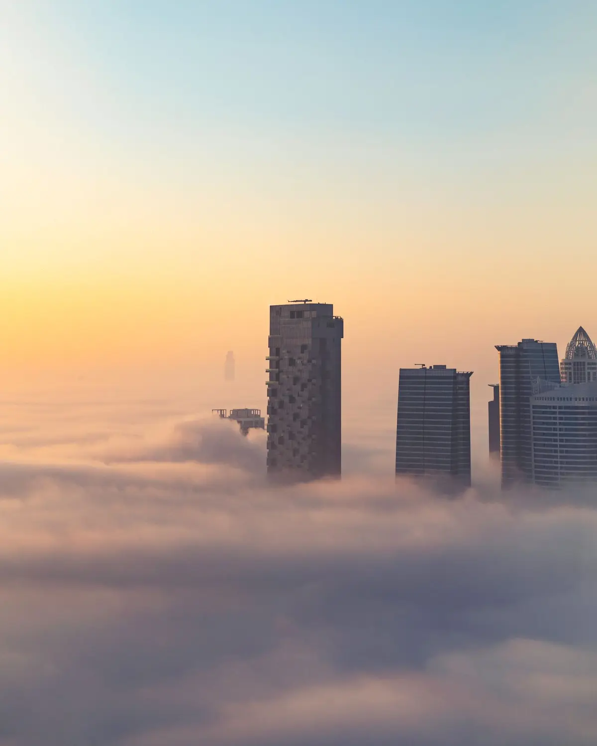Towers in Dubai rising above morning fog